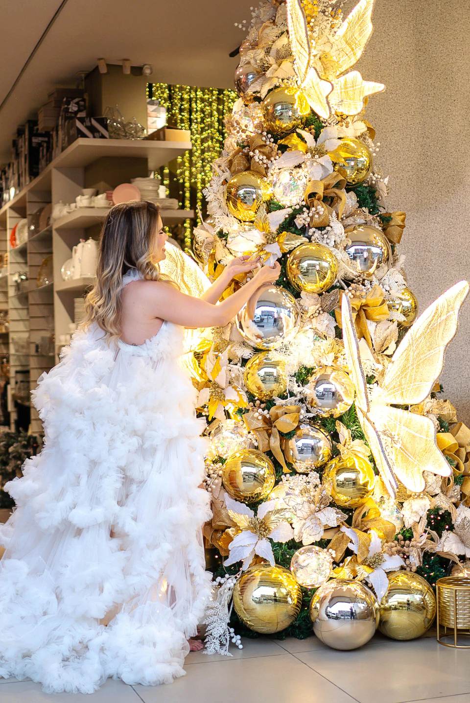 Árvore de Natal dourada da coleção Casa Nobre sendo decorada